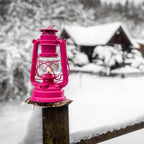Feuerhand Baby Special 276 Sturmlaterne auf Holzpfahl im Schnee mit Hintergrund von verschneitem Haus.