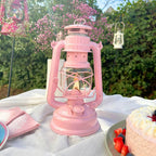 Feuerhand Baby Special 276 Sturmlaterne in pink mit Flamme, umgeben von einer festlichen Tischdeko.