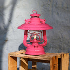 Reflektorschirm für Baby Special 276 auf einer Holzpalette, leuchtend pink mit flackernder Flamme.