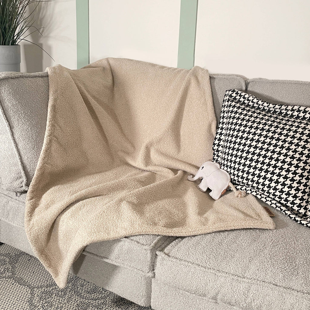 Kuschelige Hundedecke Teddy LeFluff auf dem Sofa mit Hund