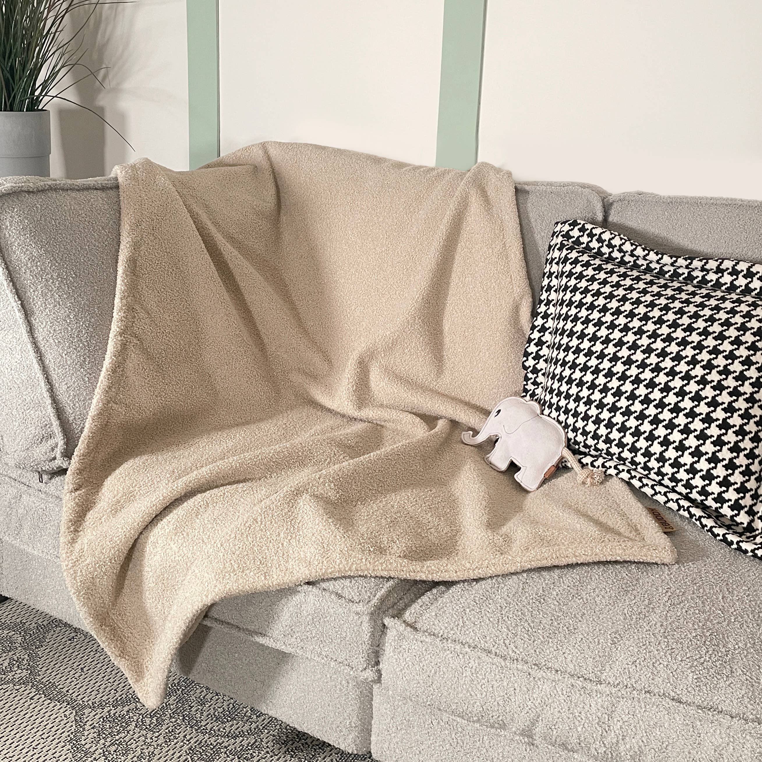 Kuschelige Hundedecke Teddy LeFluff auf dem Sofa mit Hund