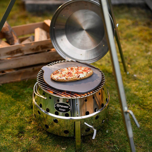 Atago Pizzastein auf dem Atago Grill mit frisch gebackenem Brot im Freien.