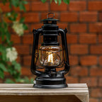 Feuerhand LED Laterne Baby Special 276 auf einem Tisch, strahlt warmes Licht in einem rustikalen Outdoor-Ambiente.