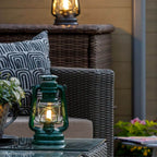 Feuerhand LED Laterne Baby Special 276 auf einem Tisch im Garten, moderne LED-Technologie kombiniert mit traditionellem Design.
