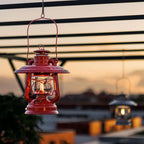 Feuerhand LED Laterne Baby Special 276 hanging with warm light during sunset on a rooftop.