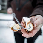 Lagerfeuer-Spieß mit Marshmallows und Schokolade über offenem Feuer ideal für Grillspaß.