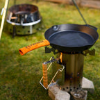Petromax Anzündkamin XL mit Pfanne auf dem Grill, ideal für schnelles Durchglühen von Holzkohle.