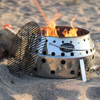 Atago Grillrost Durchmesser 34 cm auf einem Grill mit Flammen im Sandplatz.