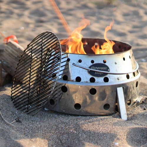 Atago Grillrost Durchmesser 34 cm auf einem Grill mit Flammen im Sandplatz.