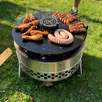 Grillplatte Tyropit und Pyron mit verschiedenen Fleischsorten auf Feuerschale im Freien.